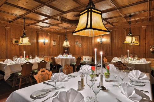 ein Esszimmer mit weißen Tischen, Stühlen und Lampen in der Unterkunft Käfernberg - Weinhotel in Alzenau in Unterfranken