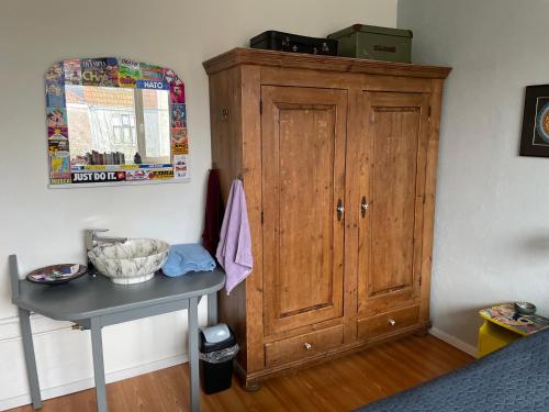 a wooden cabinet in a bedroom with a table at Comfortable Room in Alkmaar