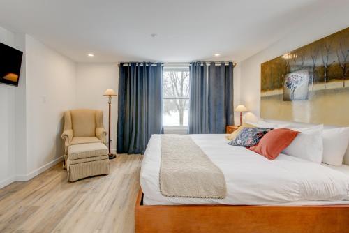 a bedroom with a large bed and a chair at Auberge Handfield et Spa in Saint-Marc-sur-Richelieu