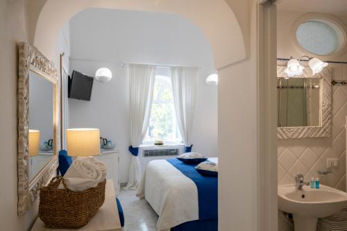 a bedroom with a bed and a sink and a mirror at Villa Dalu in Positano