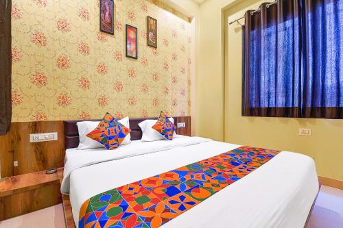 FabHotel Lotus في أودايبور: غرفة نوم مع سرير كبير مع بطانية ملونة
