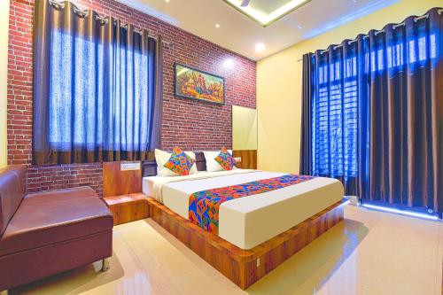 FabHotel Lotus في أودايبور: غرفة نوم بسرير ومقعد في غرفة