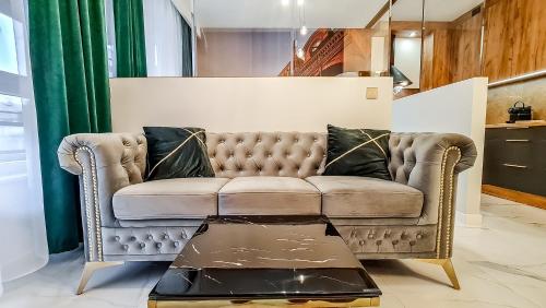 salon z kanapą i stołem w obiekcie Gold Apartament przy Księżym Młynie - Garaż - Dostęp na Kod - FV w Łodzi