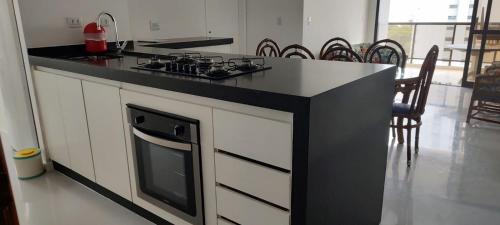 a kitchen with a black counter top and a stove at Moderno Apartamento na Enseada com Wi-Fi e Vista Espetacular - Para Família e Home Office - 300m da praia in Guarujá