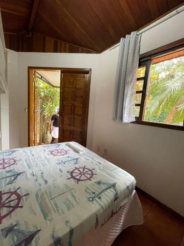 een slaapkamer met een bed en een raam bij Suítes Guaratuba in Bertioga