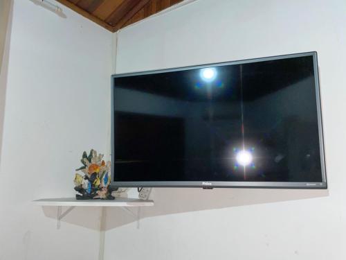 een flatscreen-tv aan een muur bij Suítes Guaratuba in Bertioga
