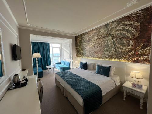 a hotel room with a bed and a painting on the wall at Adriatik Hotel, BW Premier Collection in Durrës