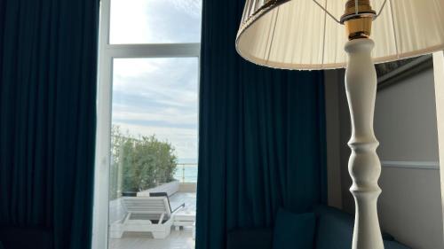 a living room with a floor lamp and a window at Adriatik Hotel, BW Premier Collection in Durrës
