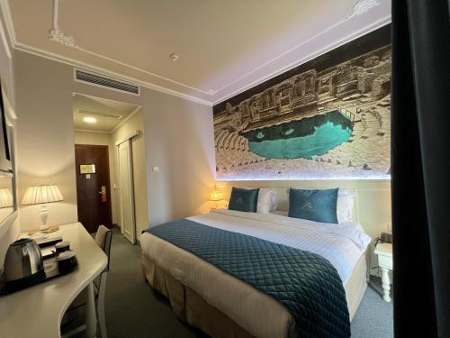 a hotel room with a bed and a painting on the wall at Adriatik Hotel, BW Premier Collection in Durrës
