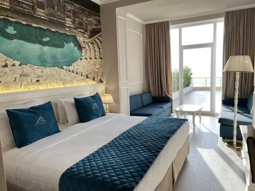 a hotel room with a large bed and a couch at Adriatik Hotel, BW Premier Collection in Durrës