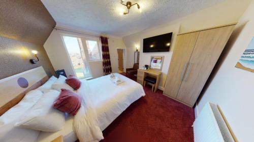 a hotel room with a large bed and a desk at Marine Lodge in Great Yarmouth