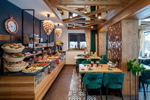 un restaurante con techos de madera, mesas y sillas verdes en Serce Tatr Residence Zakopane - blisko Krupówek, en Zakopane