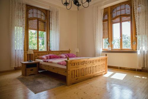 - une chambre avec un lit en bois et des fenêtres dans l'établissement Grüne Villa Wellness & Spa, à Bad Kreuznach