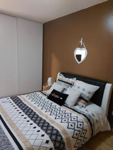 une chambre avec un lit avec une couette noire et blanche dans l'établissement Apppartement Cosy 72m2, à Tarbes