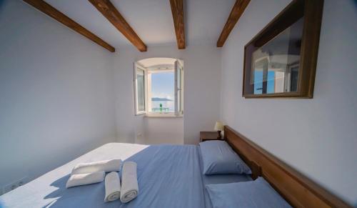 Un dormitorio con una cama con dos zapatos blancos. en Wohnung Porto, en Mošćenička Draga