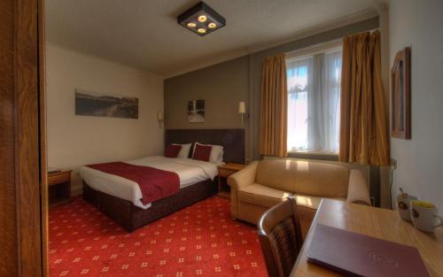 a hotel room with a bed and a chair and a table at Royal Inn in Scunthorpe