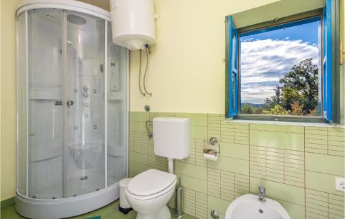 een badkamer met een toilet en een douche en een raam bij Amazing Apartment In Kastav With Kitchen in Kastav