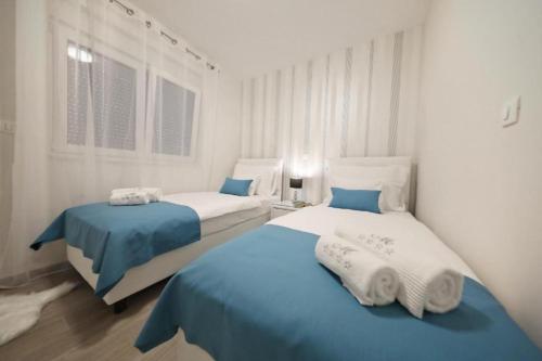 dwa łóżka w pokoju niebiesko-białym w obiekcie Luxury Majpruz Suites I w mieście Zadar
