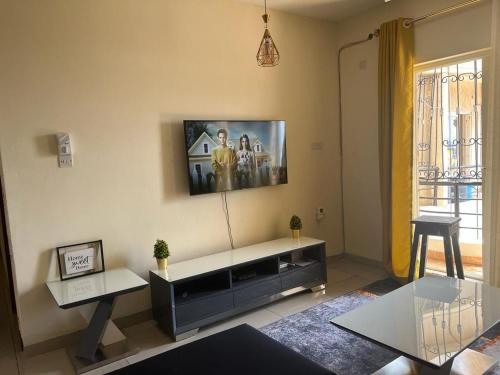 uma sala de estar com televisão na parede em Lux Suites Palm Terraces Apartments Nyali em Nyali