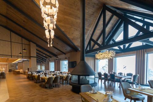 a dining room with tables and chairs and a fireplace at SARPİNO MOUNTAİN HOTEL in Sarıkamıs