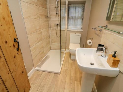 a bathroom with a shower and a sink and a toilet at Lavender Cottage in Sedbergh