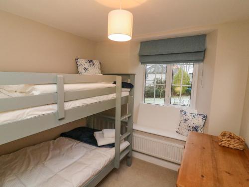 a room with two bunk beds and a table at Lavender Cottage in Sedbergh