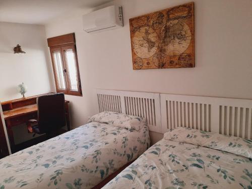 1 dormitorio con 2 camas y reloj en la pared en Spa los Balcones, en Loranca de Tajuña