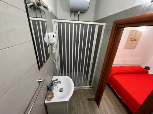 Elle comprend une petite salle de bains pourvue d'un lavabo et d'un lit rouge. dans l'établissement B&B l’antico rudere 2, à Cosenza