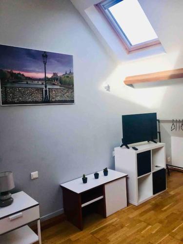 une pièce avec une table et une télévision sur un mur dans l'établissement Duplex tout confort dans Boulogne, à Boulogne-sur-Mer