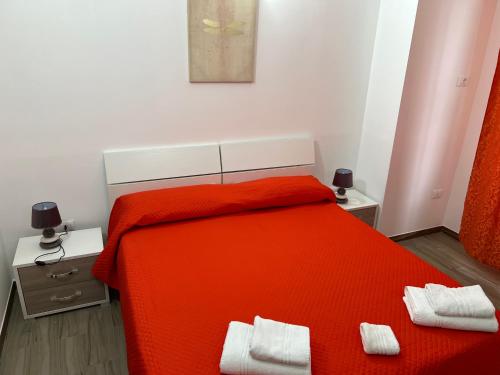 ein Schlafzimmer mit einem orangenen Bett mit zwei weißen Handtüchern darauf in der Unterkunft B&B l’antico rudere 2 in Cosenza