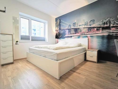 a bedroom with a large white bed with a painting on the wall at Scandian Apartments - City Park Tallinn in Tallinn