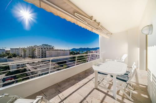 un balcon avec une table et une vue sur une ville dans l'établissement Palm beach- Free Wifi- Parking- Sea View, à Cannes