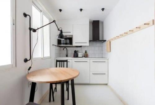a small kitchen with a wooden table and a lamp at Apartamento en Chueca Gran via con Smart TV in Madrid