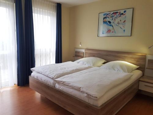 ein Schlafzimmer mit einem großen Bett mit weißer Bettwäsche in der Unterkunft Ferienwohnung 5 im Strandhaus Lobbe in Lobbe