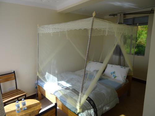 a bedroom with a bed with a canopy at Coconut Beach in Majanji