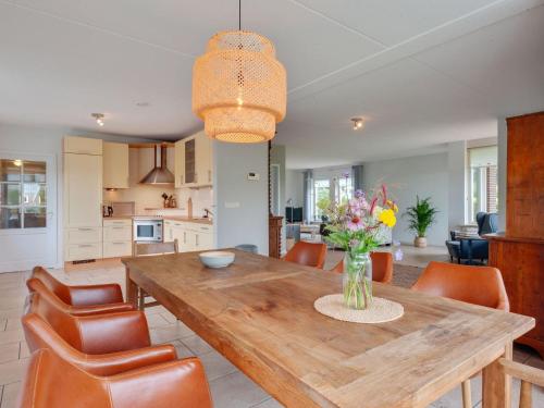 cocina y comedor con mesa de madera y sillas en Holiday home with wide views and garden en Balkbrug