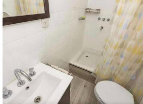 Baño blanco con lavabo y aseo en Mono ambiente Oro 2700 en Buenos Aires