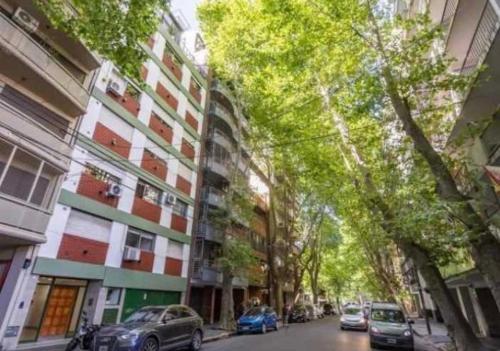 una calle de la ciudad con coches estacionados frente a los edificios en Mono ambiente Oro 2700 en Buenos Aires
