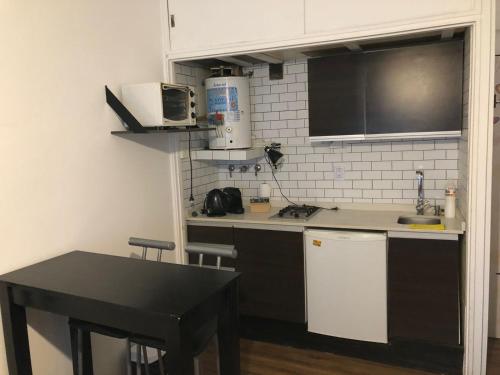 una pequeña cocina con mesa y microondas en Mono ambiente Oro 2700 en Buenos Aires