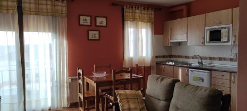 a kitchen with a table and a dining room at Apartamentos Turísticos La Casa de Dafne in Santo Tomé del Puerto