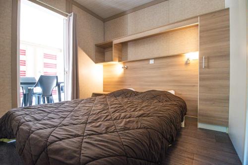 a bedroom with a bed with a wooden wall at Camping Cavallo Morto in Bonifacio