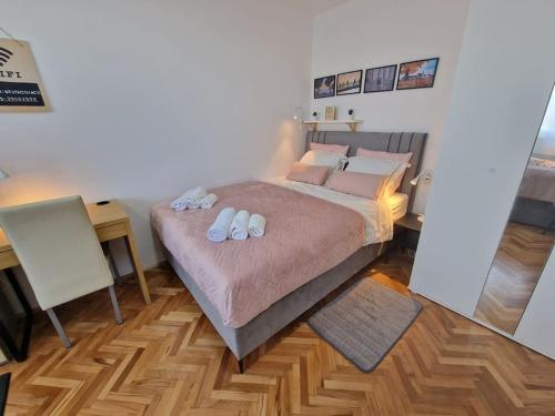 a bedroom with a large bed with two towels on it at Studio SVACIC self check in in Osijek