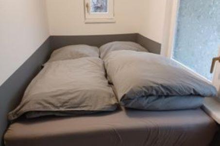 a bed with three pillows on top of it at Ferienvilla-mv in Linstow