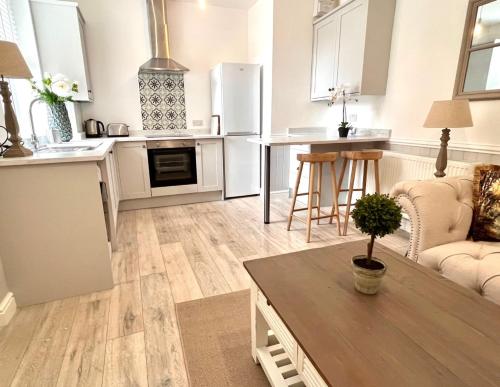 a kitchen and living room with a table at Rose Cottage at The Stables in Stannington