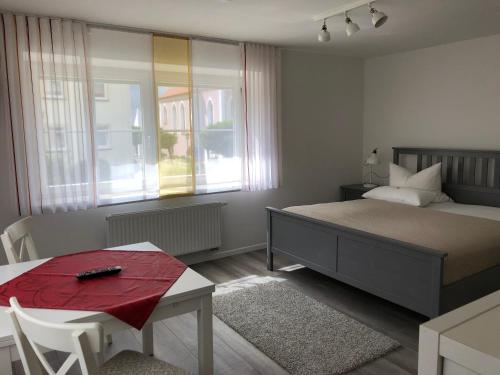 1 dormitorio con cama, mesa y ventana en Apartmentvermietung Ingrid Bolkart - Vöhlino 2, en Illertissen