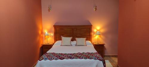 een slaapkamer met een groot bed met 2 lampen bij Apartamentos Turísticos La Casa de Dafne in Santo Tomé del Puerto
