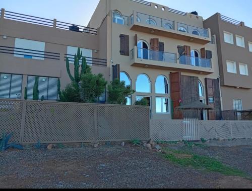 a large house with a fence in front of it at Dar diafa samira in Mirleft