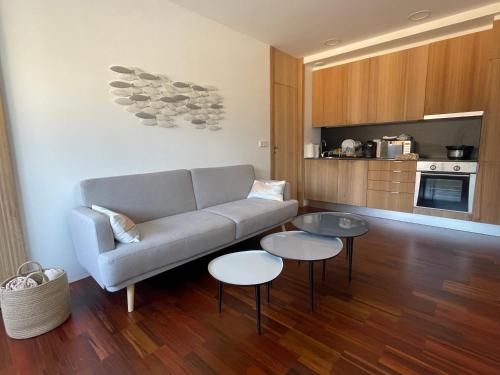 a living room with a couch and two tables at Precioso Apartamento en la Playa de Illa de Arousa in Isla de Arosa