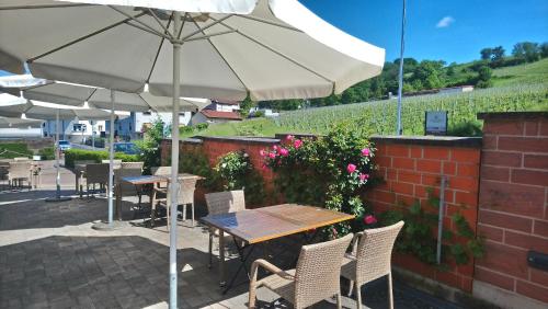 a table and chairs with an umbrella on a patio at Käfernberg - Weinhotel in Alzenau in Unterfranken