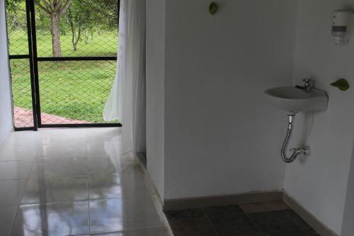 a bathroom with a sink and a door with a window at Serranía Eco Lodge in San Juan de Arama